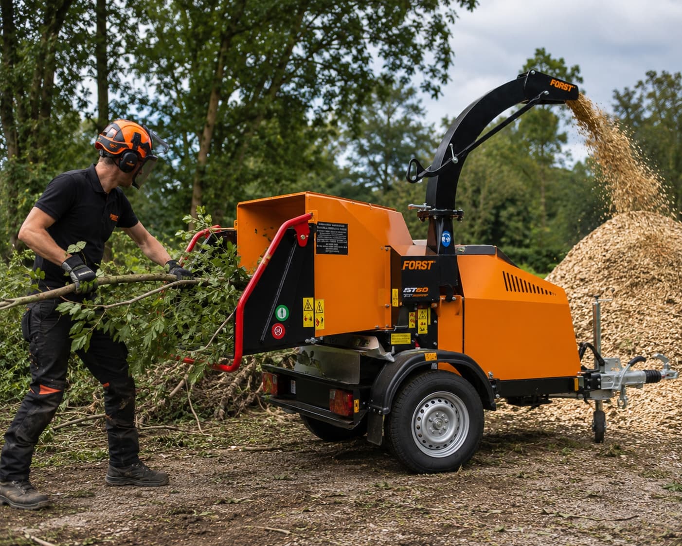 Versnipperaar van Heijboer in actie. De boomverzorger steeks een tak met bladeren in de versnipperaar en de machine versnippert de tak tot fijne snippers.